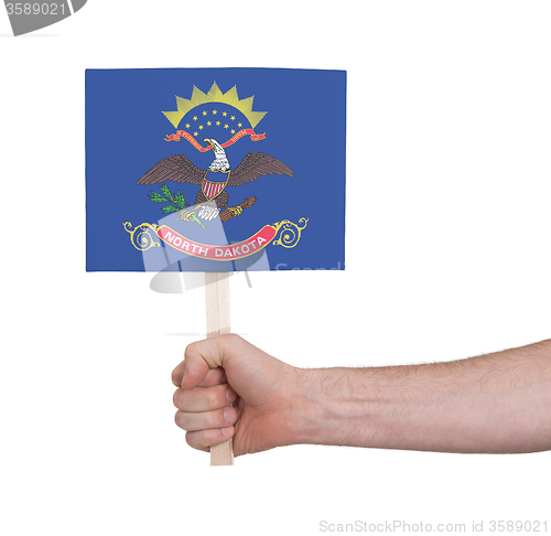 Image of Hand holding small card - Flag of North Dakota