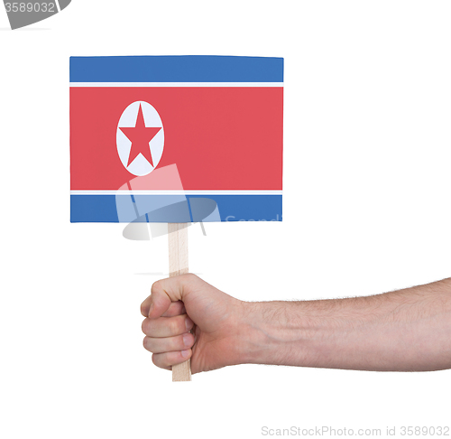 Image of Hand holding small card - Flag of North Korea