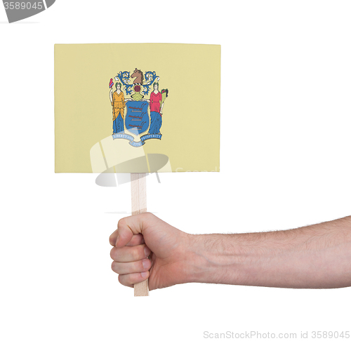 Image of Hand holding small card - Flag of New Jersey