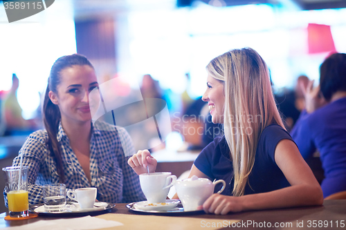 Image of girls have cup of coffee in restaurant