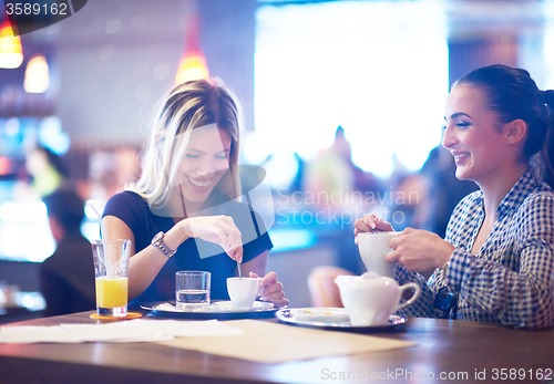 Image of girls have cup of coffee in restaurant