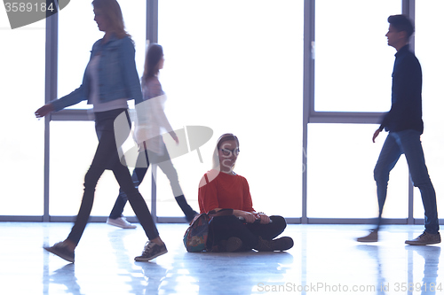 Image of student girl standing with laptop, people group passing by