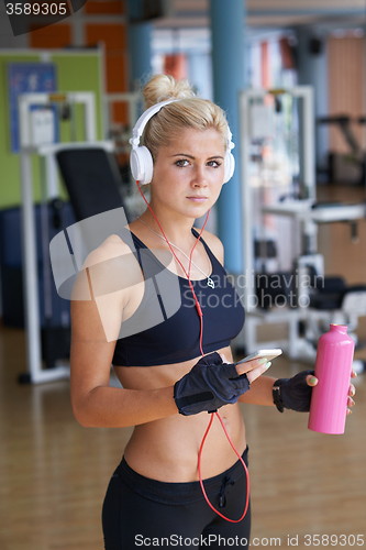 Image of woman with headphones in fitness gym
