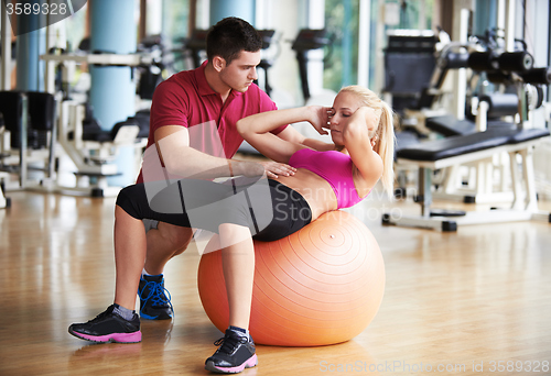 Image of young sporty woman with trainer exercise in fitness gym