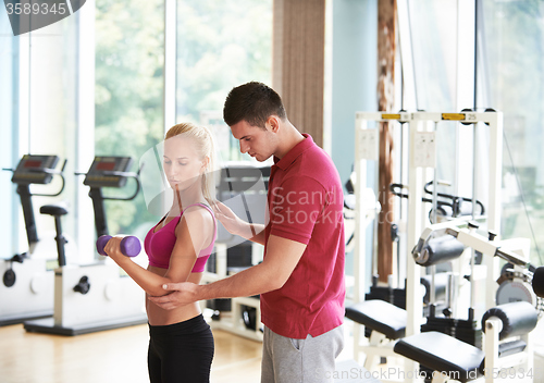 Image of young sporty woman with trainer exercise weights lifting