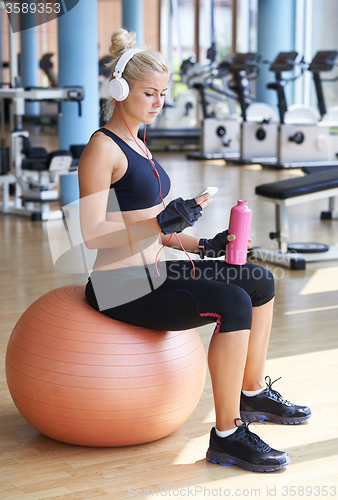 Image of woman with headphones in fitness gym