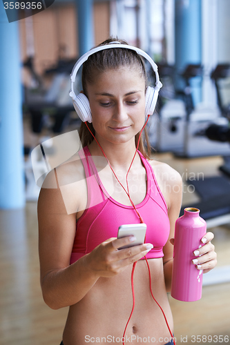 Image of woman with headphones in fitness gym