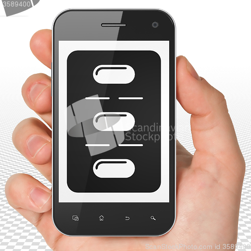 Image of Healthcare concept: Hand Holding Smartphone with Pills Blister on display