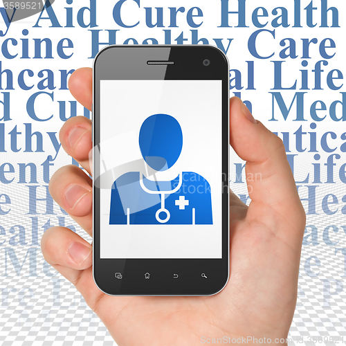 Image of Healthcare concept: Hand Holding Smartphone with Doctor on display