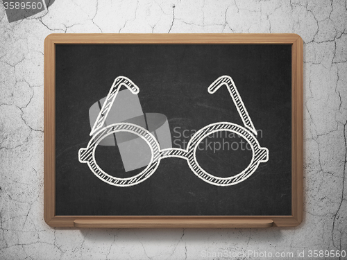 Image of Learning concept: Glasses on chalkboard background