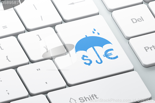 Image of Security concept: Money And Umbrella on computer keyboard background