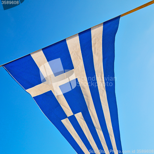 Image of waving greece flag in the blue sky and flagpole