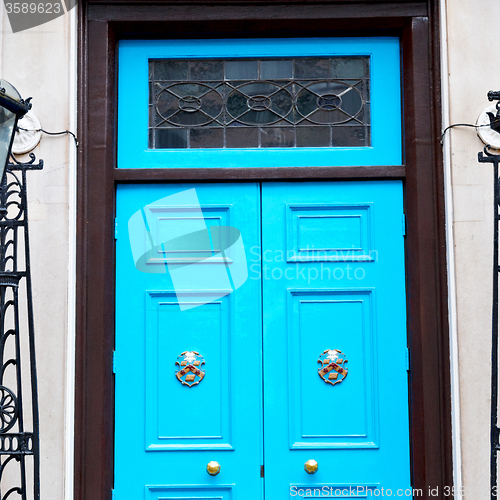 Image of  blue handle in london antique brown door  rusty  brass nail and