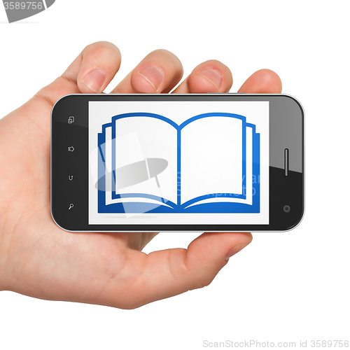 Image of Science concept: Hand Holding Smartphone with Book on display