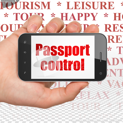 Image of Vacation concept: Hand Holding Smartphone with Passport Control on display