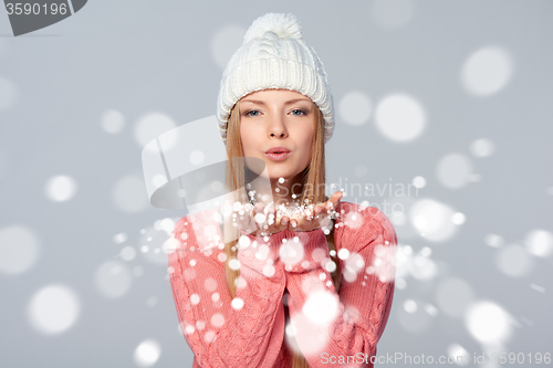 Image of Woman blowing snow at you