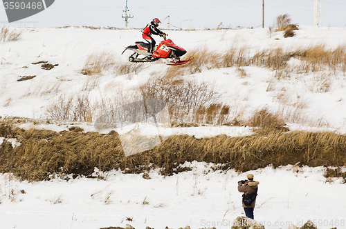 Image of Flying of sportsman on snowmobile and press man