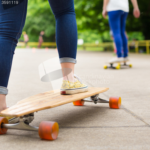 Image of Teenage girl practicing riding long board.