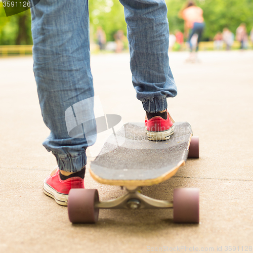 Image of Teenage girl practicing riding long board.