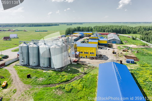 Image of Corn dryer silos standing in a field of corn