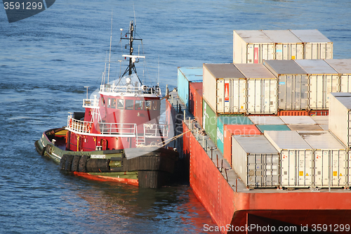 Image of Tugboat hauling cargo ship