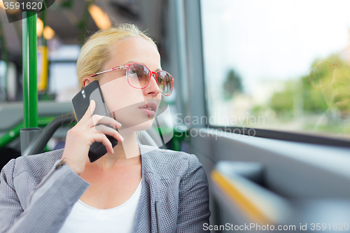Image of Blonde business woman traveling by bus.