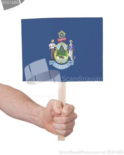 Image of Hand holding small card - Flag of Maine