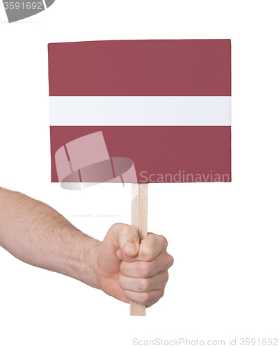 Image of Hand holding small card - Flag of Latvia