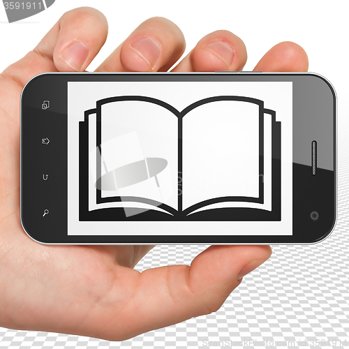 Image of Science concept: Hand Holding Smartphone with Book on display