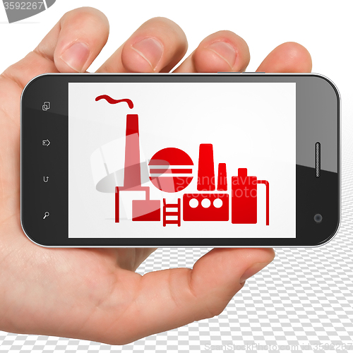 Image of Business concept: Hand Holding Smartphone with Oil And Gas Indusry on display