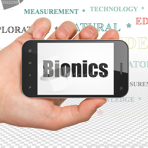 Image of Science concept: Hand Holding Smartphone with Bionics on display