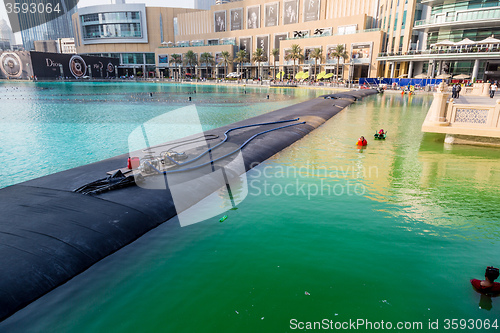 Image of Workers in uniform are cleaning pool