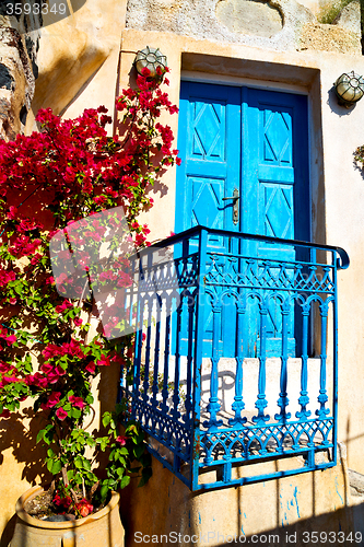 Image of blue door in antique village flower   white wall