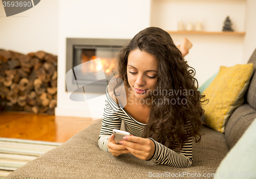 Image of Woman with her cellphone at home