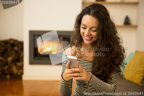 Image of Woman with her cellphone at home