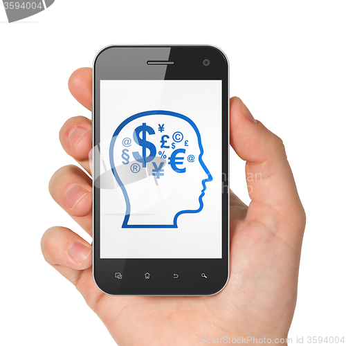 Image of Business concept: Hand Holding Smartphone with Head With Finance Symbol on display