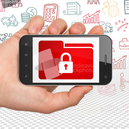 Image of Business concept: Hand Holding Smartphone with Folder With Lock on display