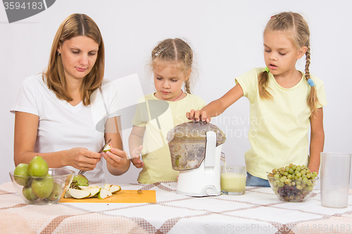 Image of Mom cut pear juice, the children throw them in a juicer