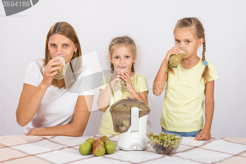 Image of Mother and two daughters drinking freshly made juice