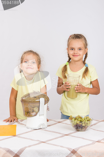 Image of Two girls squeezed fruit juice in a juicer