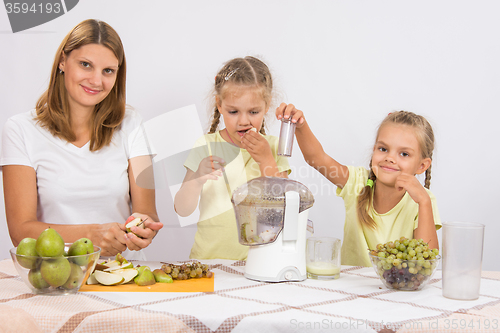 Image of Girl gnaws pears until mom and sister squeezed juice in a juicer