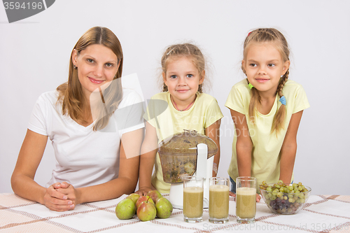 Image of Mother and two daughters to cook for three glasses of juice juicer
