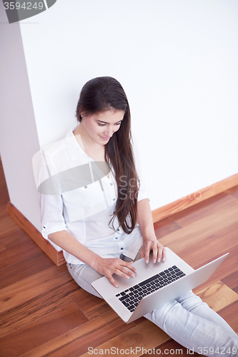 Image of relaxed young woman at home working on laptop computer