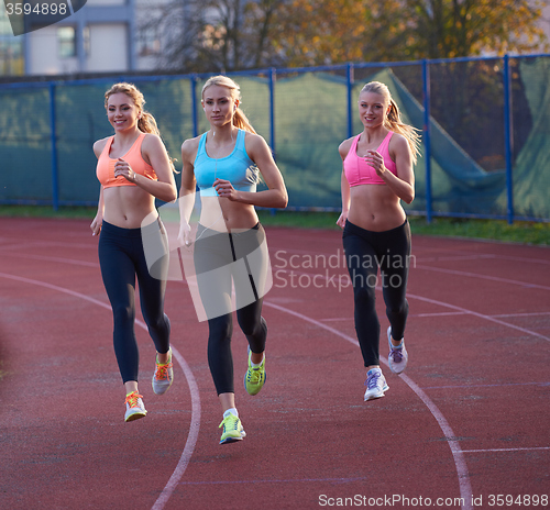 Image of athlete woman group  running on athletics race track