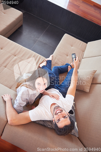 Image of young couple watching tv at home