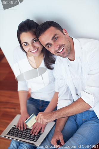 Image of relaxed young couple working on laptop computer at home