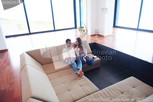 Image of relaxed young couple working on laptop computer at home