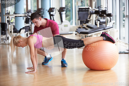 Image of young sporty woman with trainer exercise in fitness gym