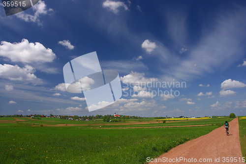 Image of Blue sky and gravel route with cyklist.