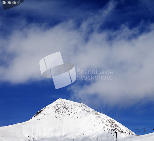 Image of Chair-lift and ski slope at sun wind day